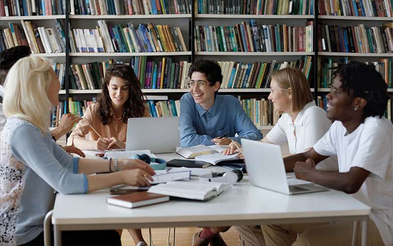 Male and female students studying in school library